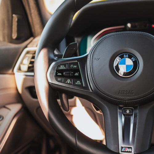 Close up shot of a matte black aluminium paddle shifters set installed in a BMW G20
