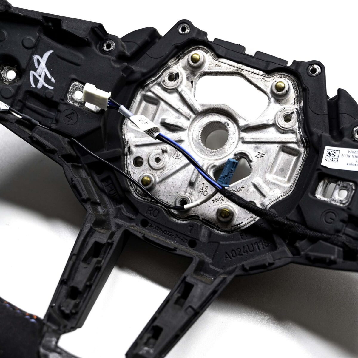 Close up shot of the OEM BMW M Flat bottom alcantara steering wheel 32307908502 showing the cables