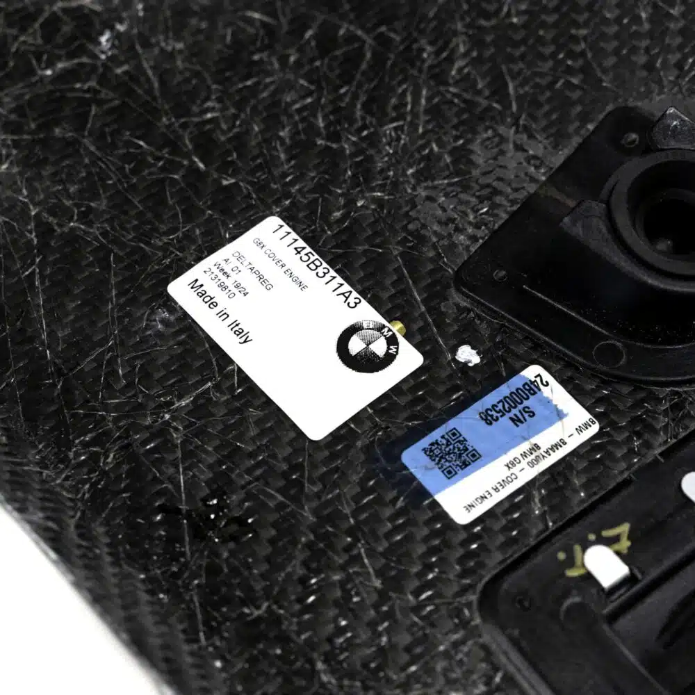 Close up shot of the OEM BMW Carbon fiber engine cover for S58 engines 11145B311A3 showing labels on the inside