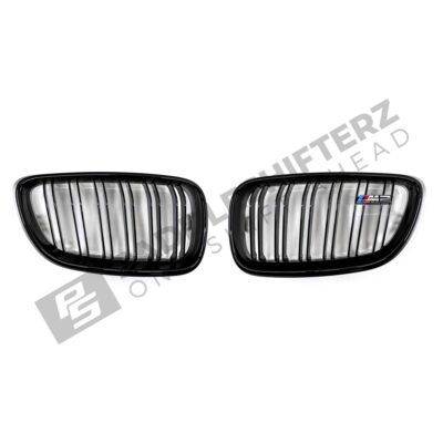 A top down shot of the PaddleShifterz OEM BMW Gloss Black front grilles BMW F87 M2 51712355447 51712355448 laid down on a white background