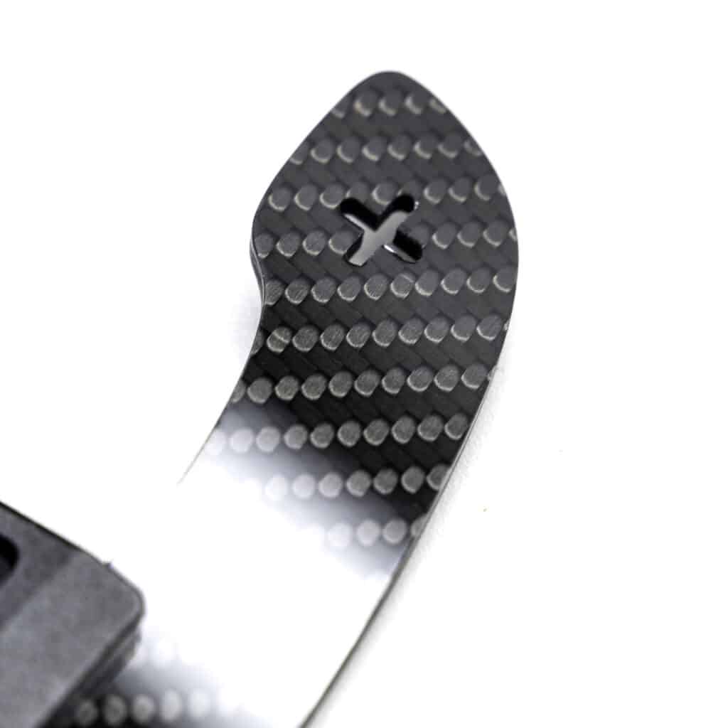 Super close up photo of a gloss carbon fiber paddle shifter, right side with + sign cut out