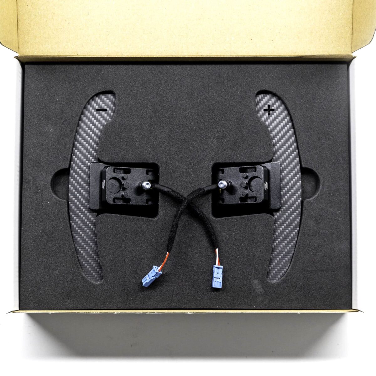 Structured carbon fiber paddle shifters with magnetic component in a box with foam insert